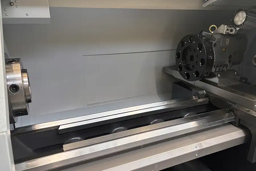 Vnitřní pohled na CNC soustruh STYLE 510 s dlouhým ložem stroje a revolverovou hlavou pro přesné obrábění