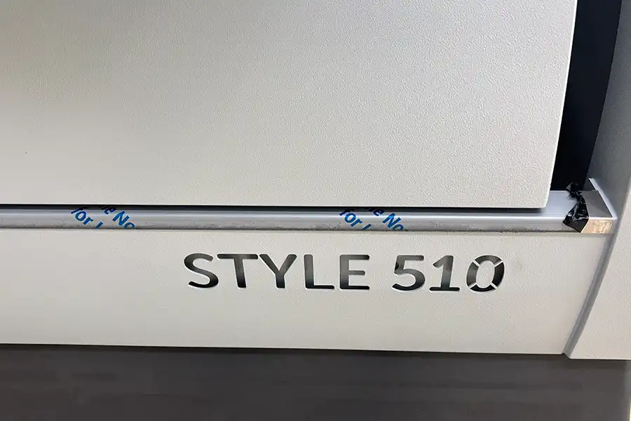 Detail krytu CNC soustruhu STYLE 510 s označením modelu a pevnou konstrukcí stroje